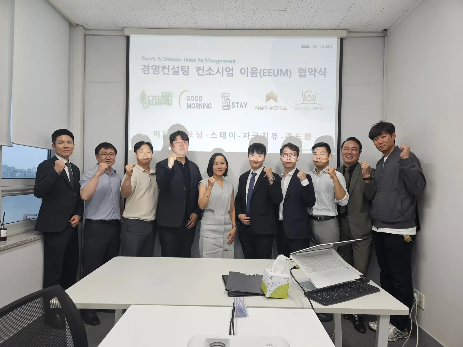회의실에서 단체로 기념 촬영한 모습